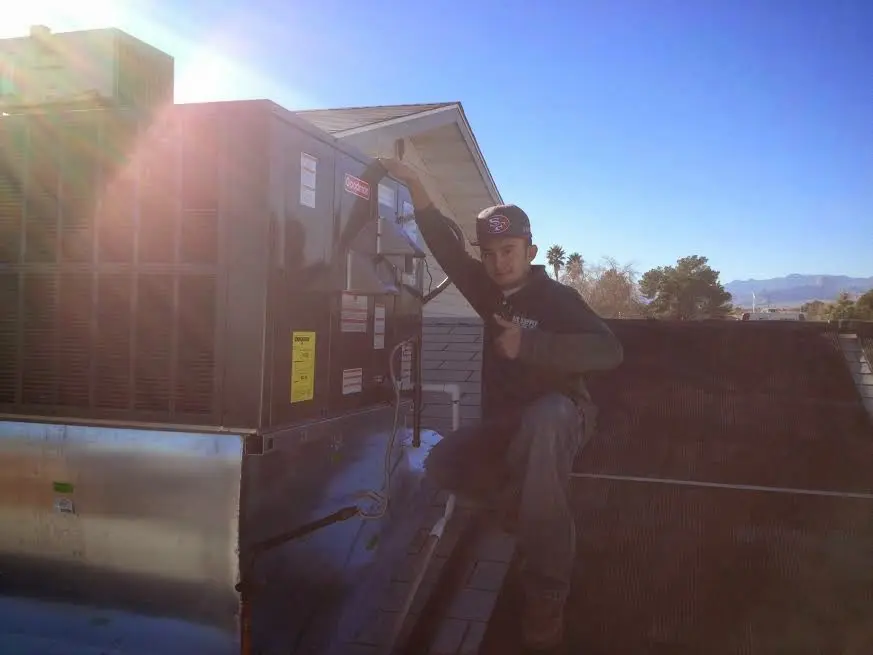 HVAC technician performing Air Duct Cleaning on a rooftop unit in Stanton
